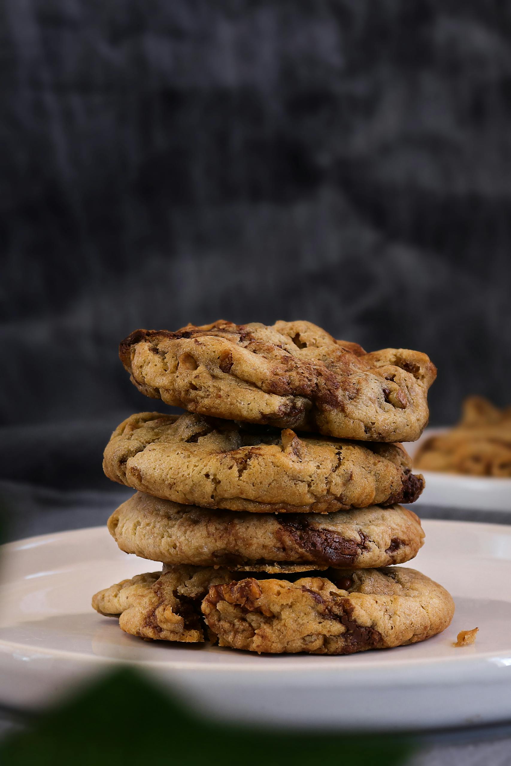 Delicious stack of homemade chocolate chip cookies on a white plate, perfect for a sweet treat.