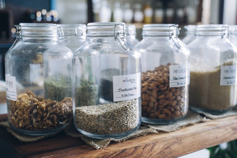Glass jars filled with organic seeds and nuts on display in an eco-friendly store.